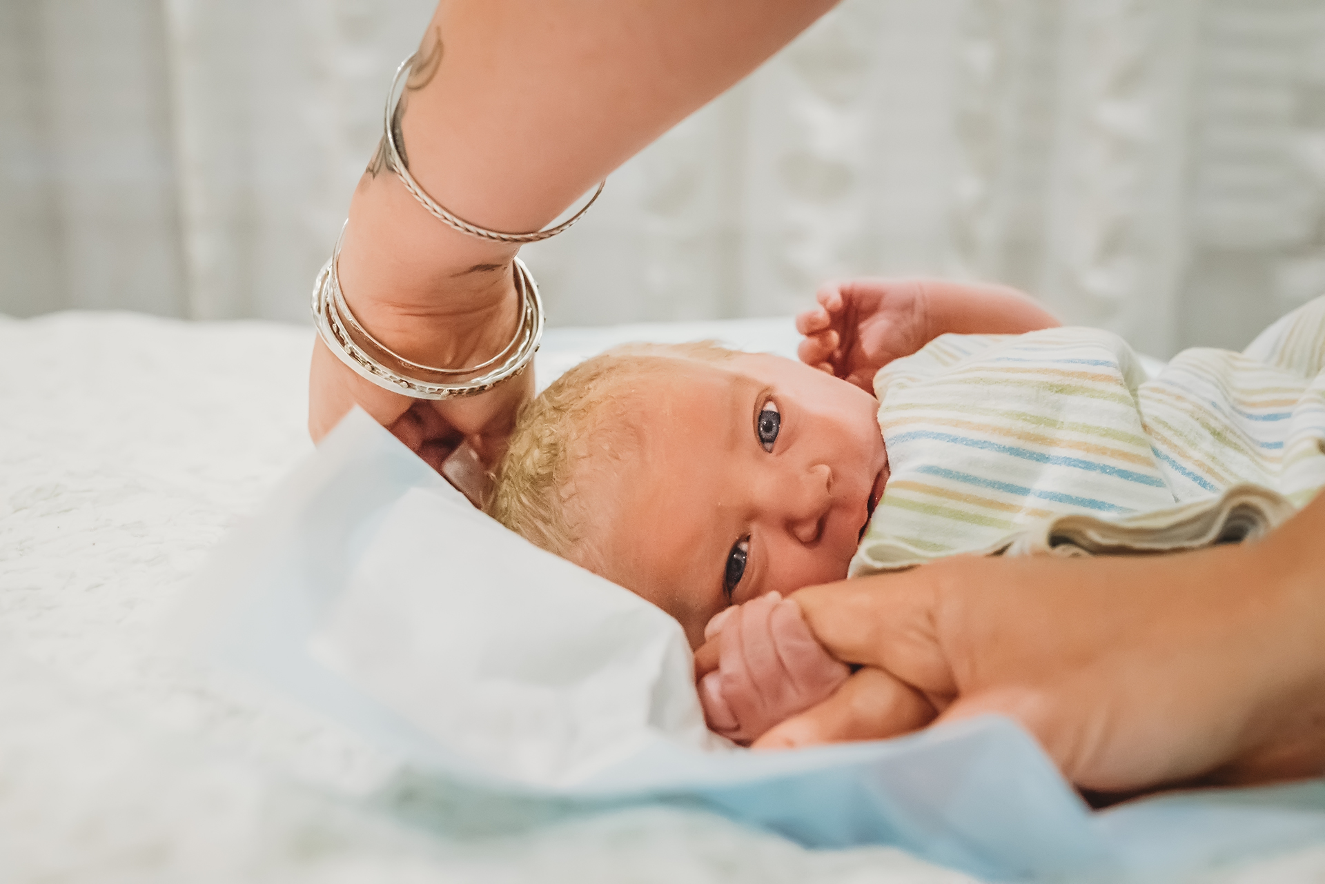 Healthy baby girl with blue eyes and blonde hair is quiet alert after birth Healthy baby girl with blue eyes and blonde hair is quiet alert after birth