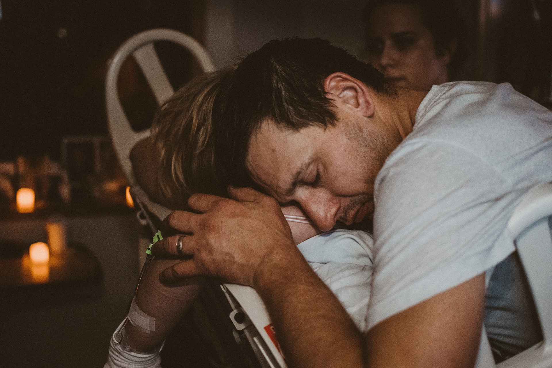 Birth partner husband holds his wife's shoulders during labor Birth partner husband holds his wife's shoulders during labor