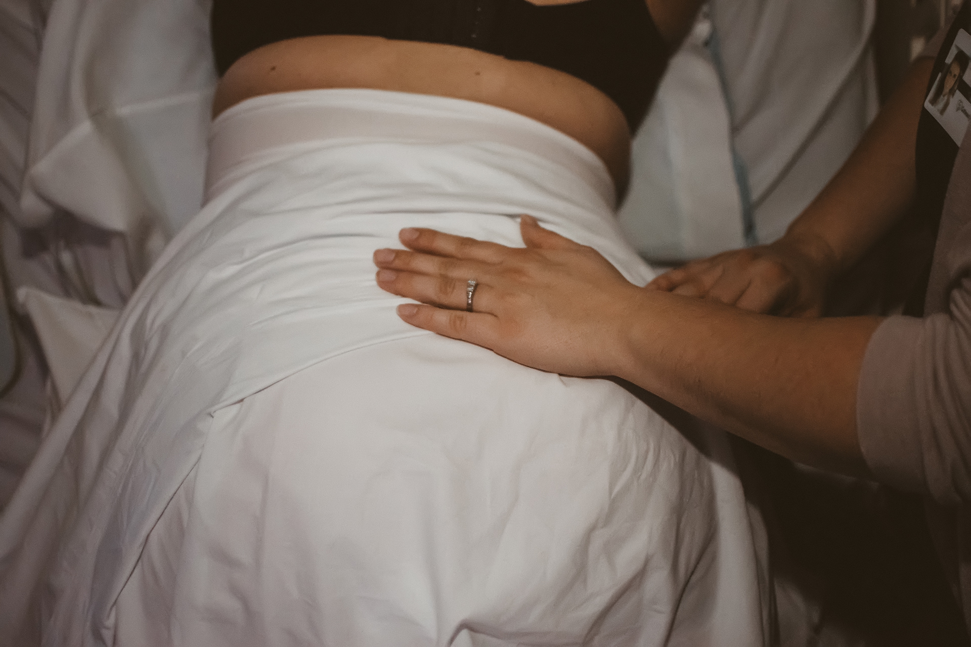 Doula places her hand on laboring mother's lower back during a contraction Doula places her hand on laboring mother's lower back during a contraction
