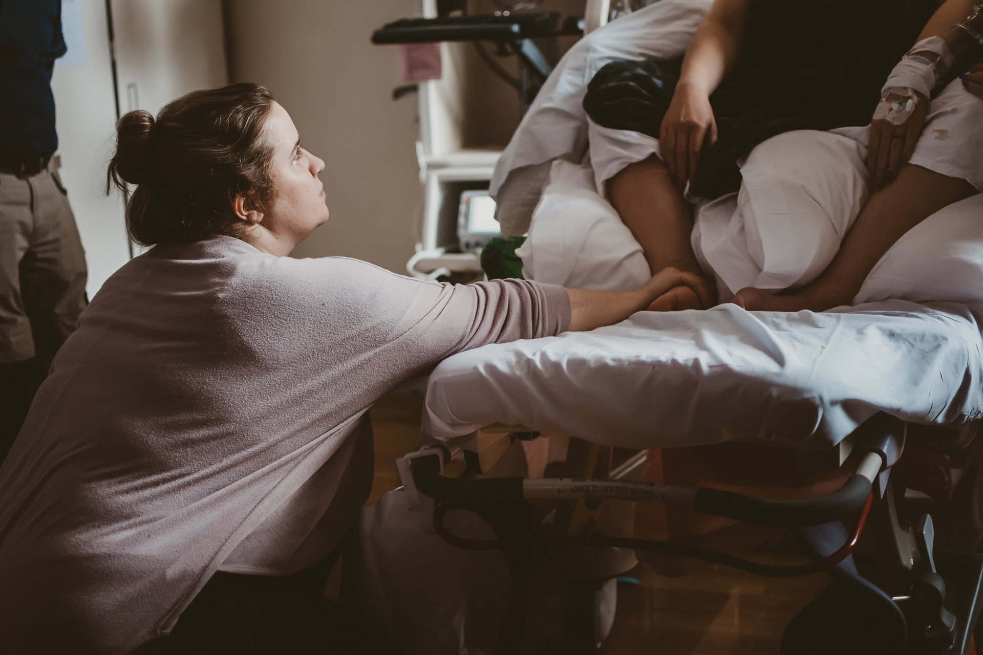 Doula reaches out to comfort a woman in labor before the birth of her child Doula reaches out to comfort a woman in labor before the birth of her child