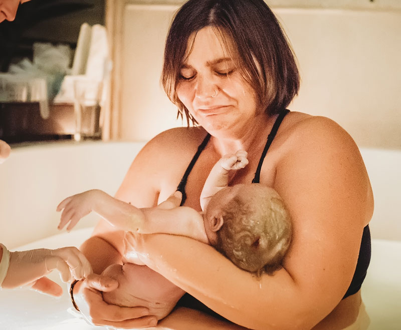 Mother is overcome with emotion holding her baby for the first time waterbirth Mother is overcome with emotion holding her baby for the first time waterbirth