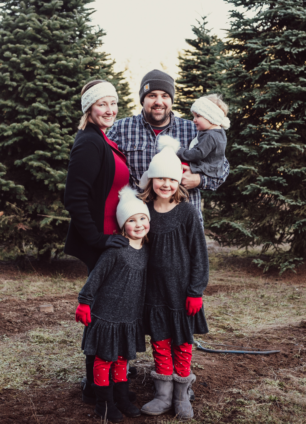 Family portrait at Trenholm Christmas tree farm, three children and their parents wearing white hats and red gloves Family portrait at Trenholm Christmas tree farm, three children and their parents wearing white hats and red gloves